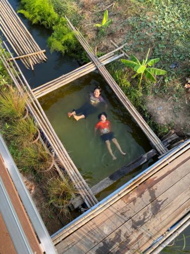 two people swimming in a pool of water at Royal mountain view (วิวเขาหลวง) in Ratchaburi