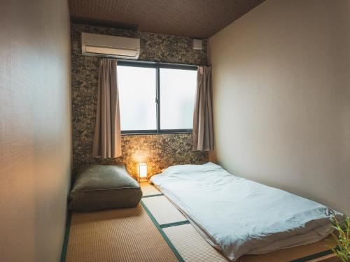 大阪市にある-智 tomo- 難波 天王寺まで約15分 大阪観光に便利な和風宿 無料Wi-Fiのベッドと窓のある小さな部屋
