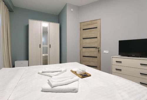 a bedroom with a bed with towels and a tv at Hayq Hotel in Yerevan