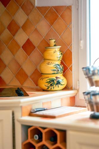 une pile de vases jaunes assis sur une étagère dans l'établissement Villa Pérouard, à Lorgues