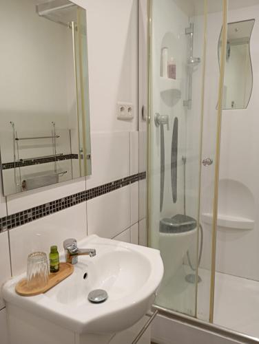 une salle de bain blanche avec un lavabo et une douche dans l'établissement Appartement 3 pièces, jardin, garage, à Laroque-des-Albères
