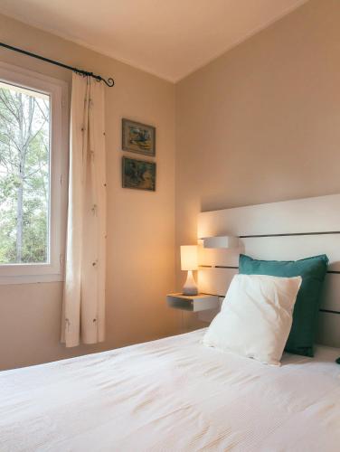 une chambre avec un lit blanc et une fenêtre dans l'établissement Villa Pérouard, à Lorgues