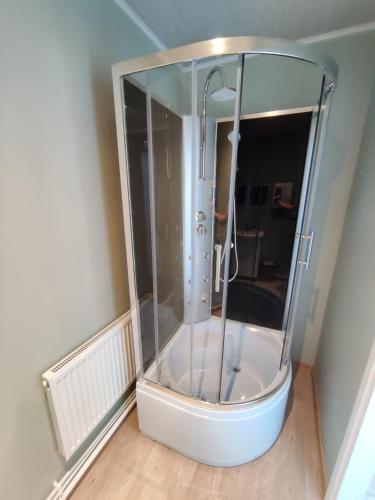 a shower with a glass enclosure in a room at Puhkemaja Peretuba in Obinitsa