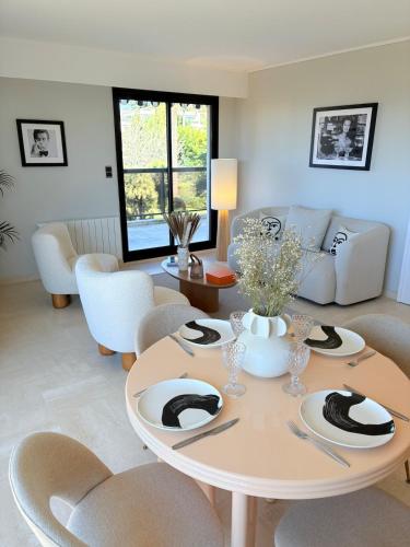 un salon avec une table et des chaises dans l'établissement Dernier étage-PISCINE-TENNIS-2 terrasses-Garage-Wifi, à Cannes