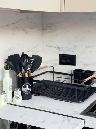 un bancone da cucina con un contenitore nero di utensili di Sunset Rental a Durrës