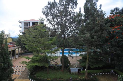 a view of a pool with trees and a building at Central Jimma Hotel in Jīma