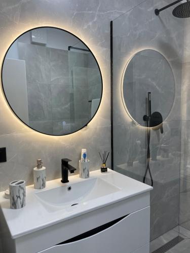 un bagno con lavandino bianco e specchio di Sunset Rental a Durrës