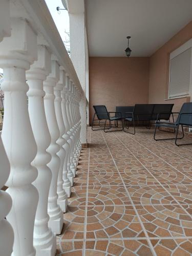 a hallway with white columns and tables and chairs at Apartmani Dino in Bilice