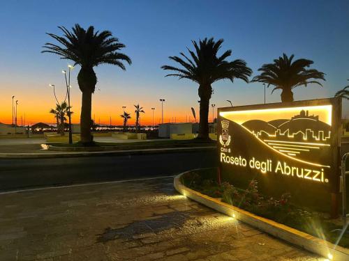 a sign on the side of a road with palm trees at Appartamento Leon in Roseto degli Abruzzi