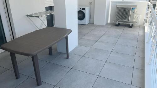a table and chair in a room with a washing machine at Appartamento Leon in Roseto degli Abruzzi