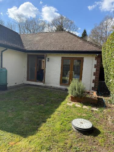 a house with a frisbee in the yard at Private Five Bedroom Bungalow in Chertsey in Chertsey