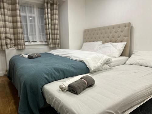 two beds sitting next to each other in a bedroom at A Cosy Ground Floor Flat in London