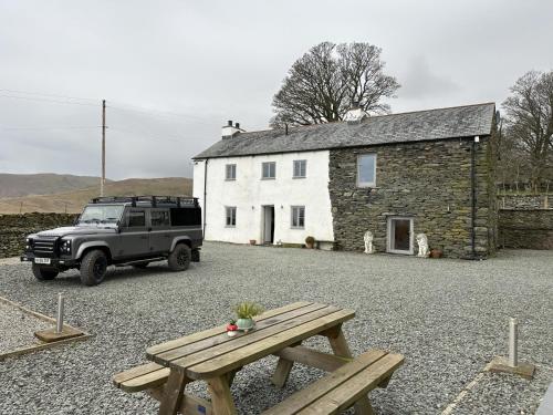 a jeep parked in front of a white building at Lower Carhullan in Penrith