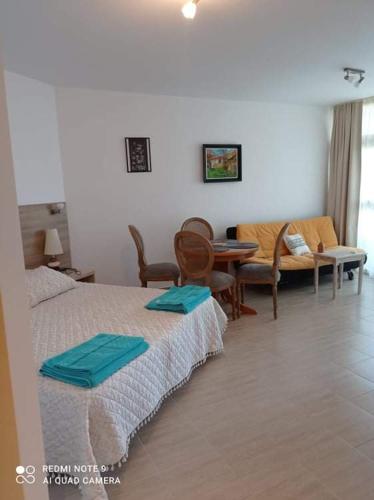 a hotel room with two beds and a table and chairs at Studio Quatro - South Pearl - Sozopol in Sozopol