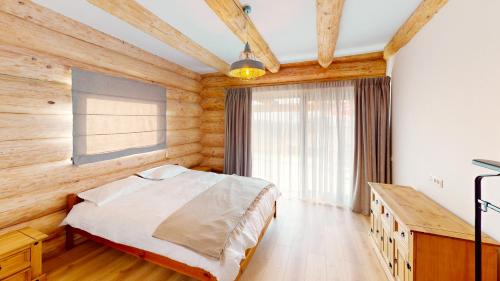 a bedroom with a bed and a wooden wall at Cabana Ursului Tebea in Ţebea