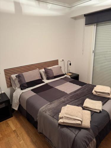 a bedroom with a large bed with towels on it at casa habana in Carballino