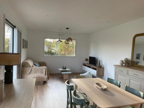 un salon avec une table, des chaises et un canapé dans l'établissement Jolie maison proche des plages, à Plonéour-Lanvern