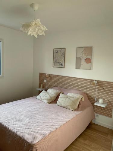 une chambre avec un lit avec deux oreillers dessus dans l'établissement Jolie maison proche des plages, à Plonéour-Lanvern