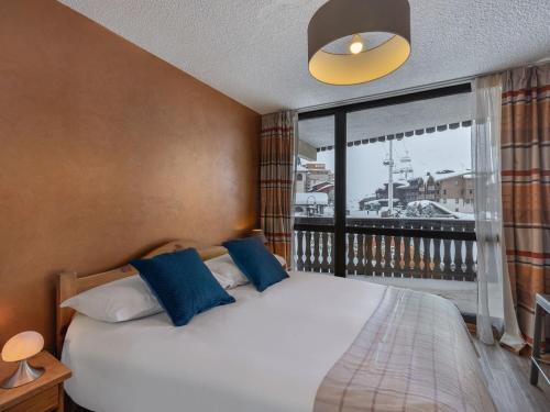 une chambre avec un lit et une grande fenêtre dans l'établissement Skis aux pieds - 9 personnes - Val Thorens, à Val Thorens