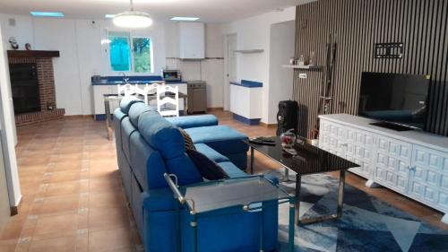 a living room with a blue couch and a table at Villa relax todo verde natural in Almuñécar