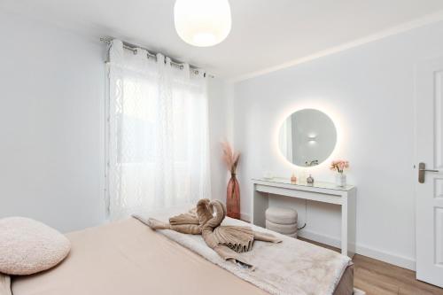 une chambre blanche avec un lit et un miroir dans l'établissement VILLA RENAISSANCE II - Somptueux deux pièces - Monaco - Parking Gratuit, à Beausoleil