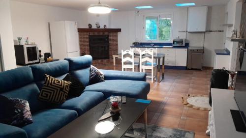 a living room with a blue couch and a table at Villa relax todo verde natural in Almuñécar