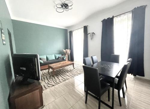 un salon avec un canapé et une table avec une télévision dans l'établissement Cosy Family trip, à Nice