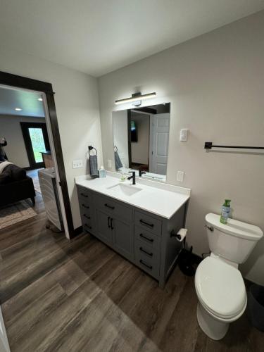 a bathroom with a sink and a toilet and a mirror at Sportsman Lodge Melrose MT in Melrose