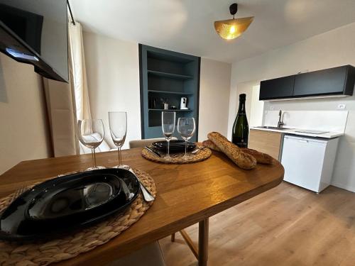 - une cuisine avec une table en bois et des verres à vin dans l'établissement E2 Reton Studio Cosy proche du centre-ville, à Épernay