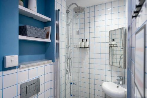 a white bathroom with a sink and a shower at Mandera's Boutique Suites & Dorms in Valletta