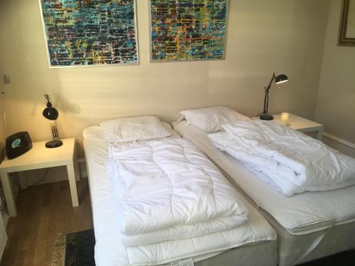 a white bed with two pillows on it in a room at Hostel California in Hinge