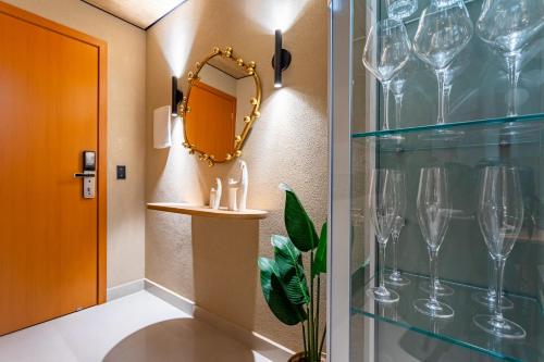 - un couloir avec des verres à vin et un miroir dans l'établissement Apê Premium e Piscina no Bueno - Vista Bueno 2606, à Goiânia