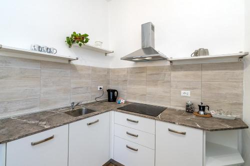 a kitchen with white cabinets and a sink at San Biagio apartment in Finale Ligure