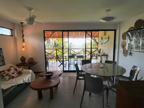 a living room with a table and a couch at Casa Turmalina in Japaratinga
