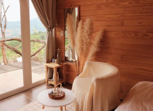 a living room with a chair and a large window at Dreamers Garden Farmstay in Hoat