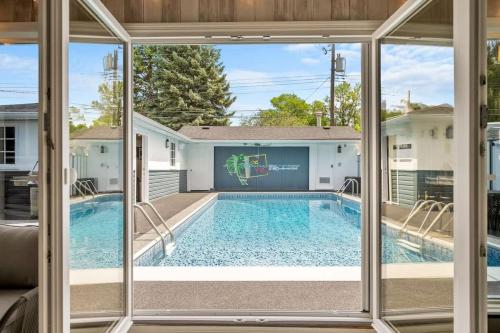 a swimming pool seen through a sliding glass door at The Experience - Pool Hot Tub Theater Games Rm Pub in Calgary