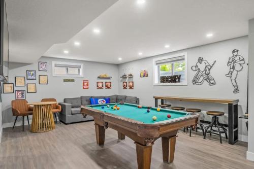 a living room with a pool table in it at The Experience - Pool Hot Tub Theater Games Rm Pub in Calgary