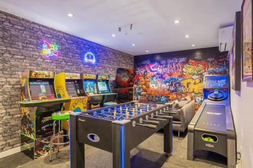 a room with arcade games and a gaming system at The Experience - Pool Hot Tub Theater Games Rm Pub in Calgary