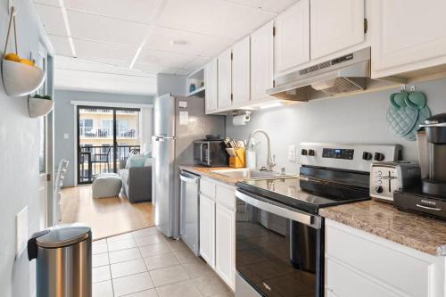 a kitchen with white cabinets and stainless steel appliances at OC Boardwalk with Ocean View in Ocean City
