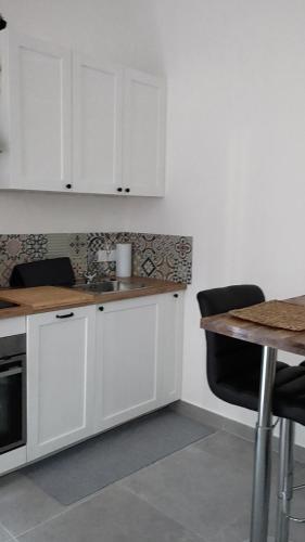 une cuisine avec des armoires blanches et un comptoir en bois dans l'établissement Studio 