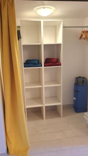 a closet with white shelves in a room at Villa GABY in Châtelaillon-Plage