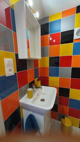 a bathroom with a white sink and colorful tiles at Villa GABY in Châtelaillon-Plage
