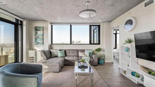 a living room with a couch and a tv at Executive Sky LUX - 2 BD 2BA Views Pool Patio & Gym in Calgary