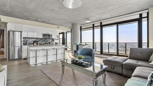 a living room with a couch and a table at Executive Sky LUX - 2 BD 2BA Views Pool Patio & Gym in Calgary