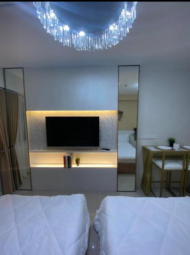 马尼拉Stunning Hotel Feels at Shore的一间带镜子、电视和床的卧室