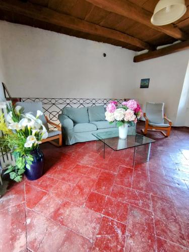 a living room with a couch and flowers on a tile floor at La Corte sul lago in Ameno