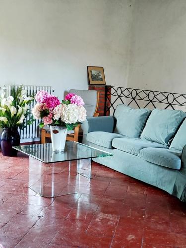 a living room with a couch and a table with flowers at La Corte sul lago in Ameno