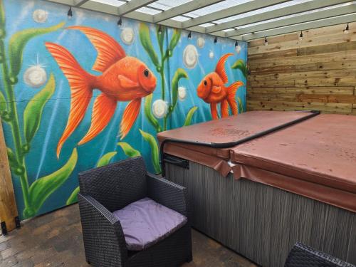 a room with a painting of two orange fish at Eden Rose Cottage hot-tub jacuzzi morecambe-bay in Morecambe