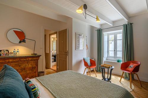 une chambre avec un lit et deux chaises et une fenêtre dans l'établissement Le 29 d'à côté, à Pont-Croix
