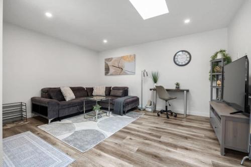 a living room with a couch and a tv at Winston Suite 2BR 1BA - Carriage Suite with Garage in Calgary